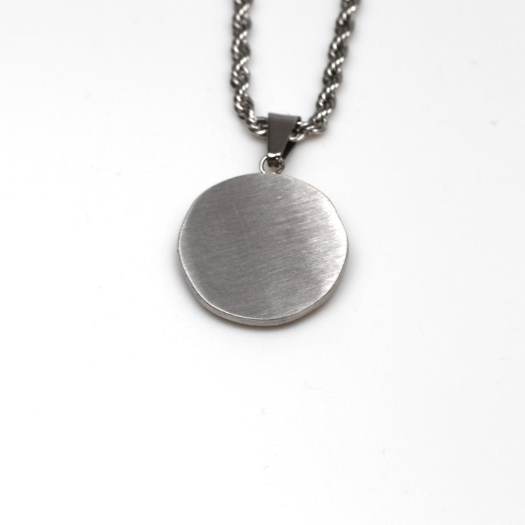 Silver necklace with a round pendant on a white background