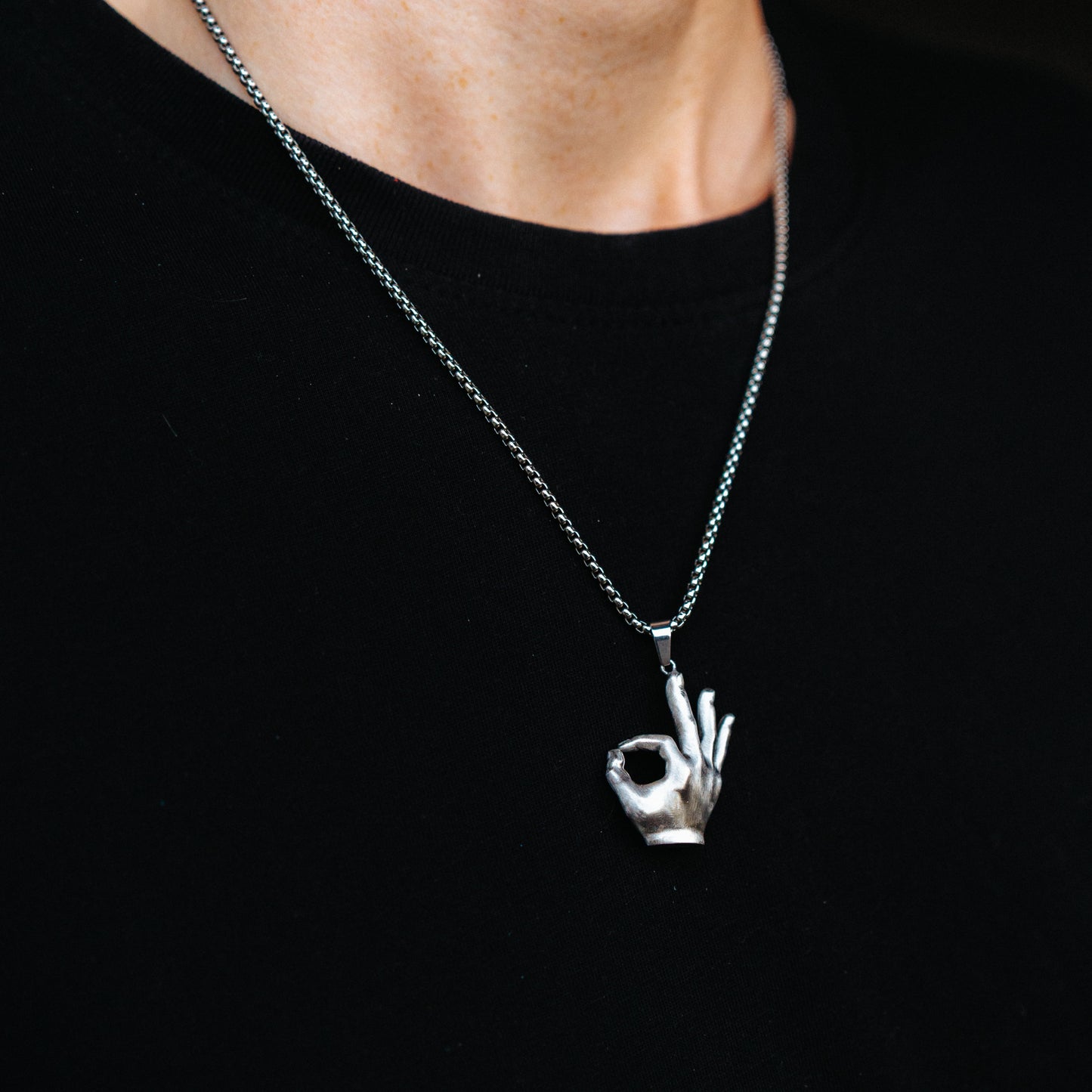 Necklace with a hand-shaped pendant on a black background