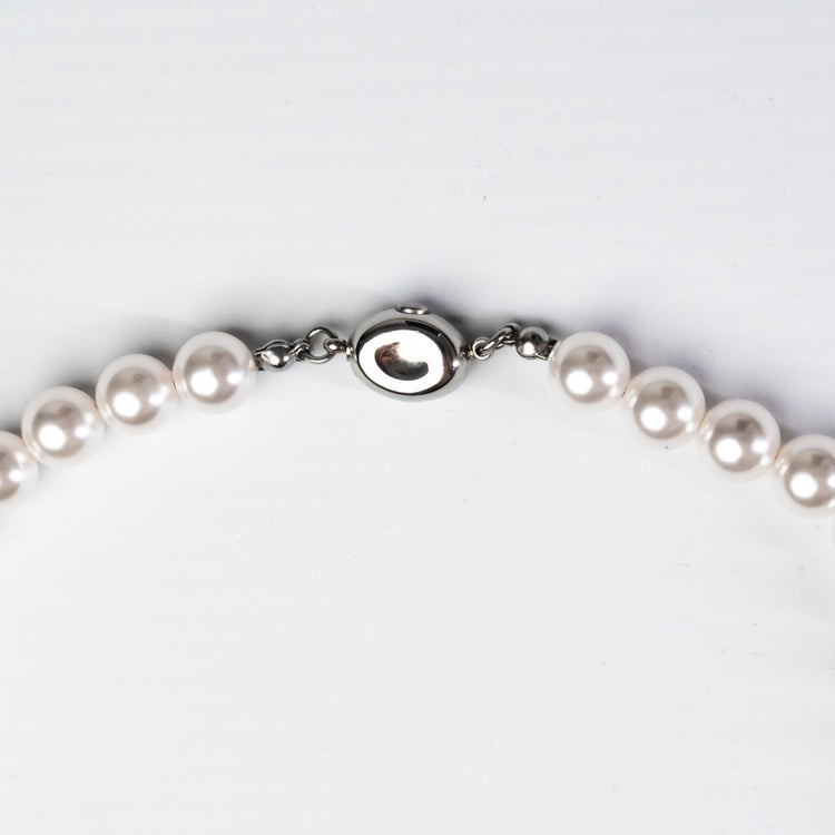 Pearl necklace with a silver clasp on a white background