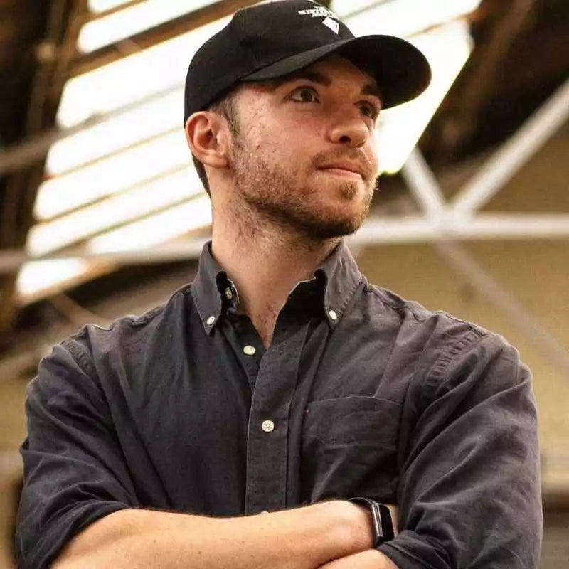Man wearing a black cap and dark shirt indoors