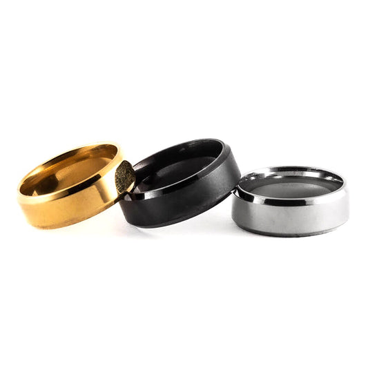 Three rings in gold, black, and silver on a white background