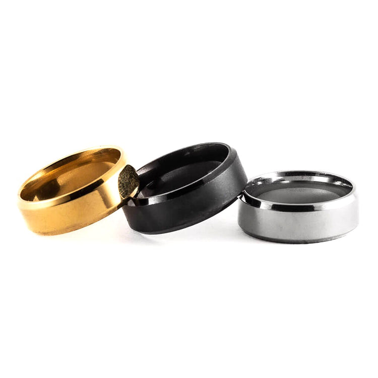 Three rings in gold, black, and silver on a white background